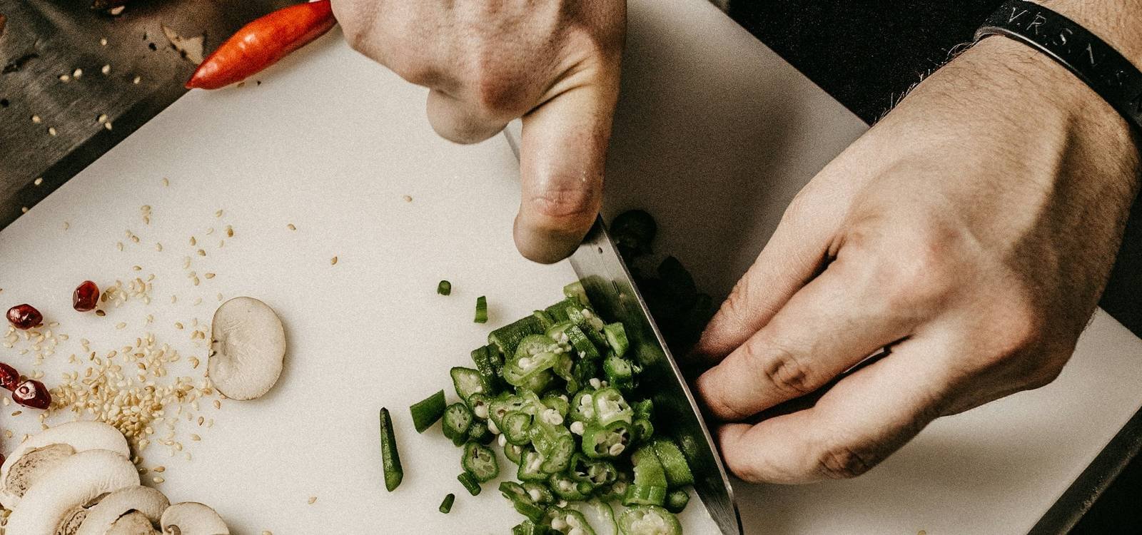 A chef's hands finely chopping vegetables