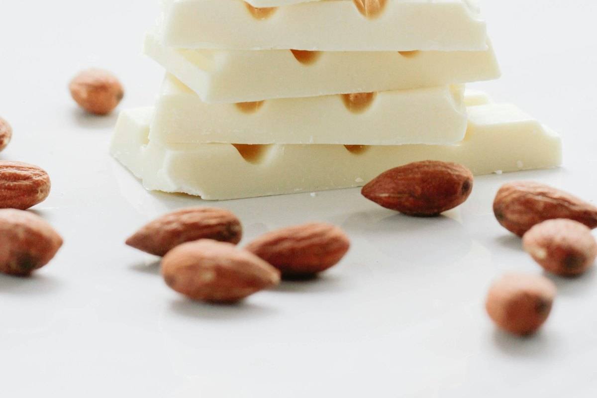 Stacked white chocolate pieces with whole almonds