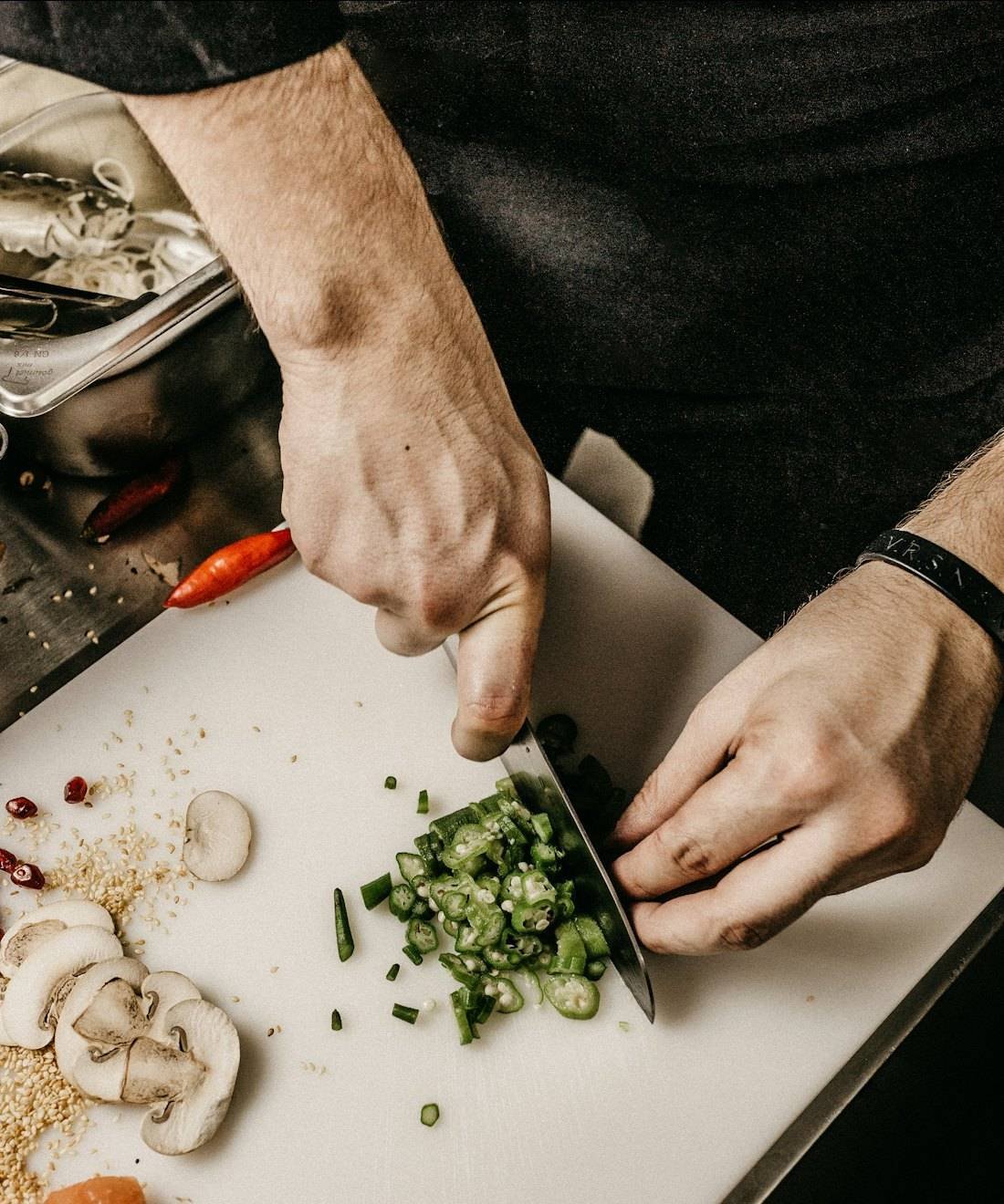 A chef's hands finely chopping vegetables