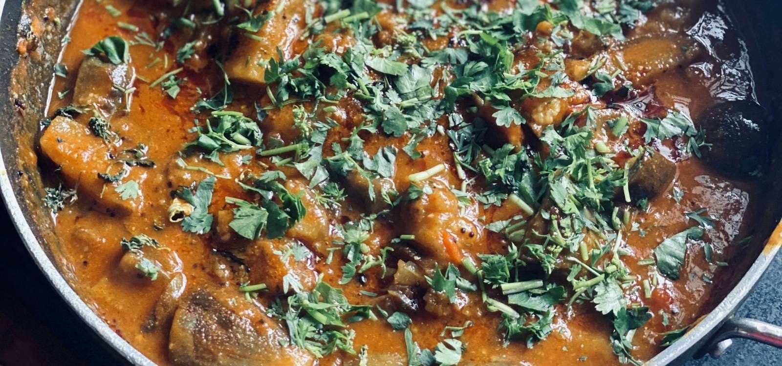 A pan of curry finished with fresh herbs