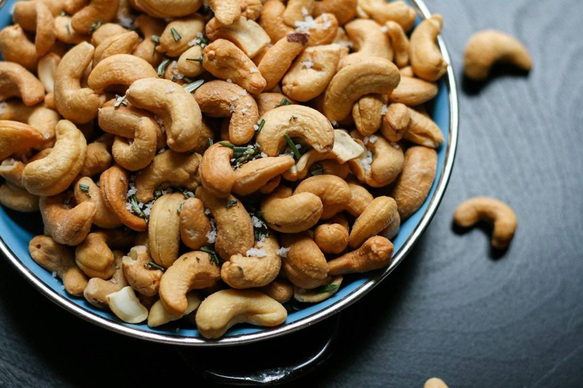 Seasoned roasted cashews in a blue bowl
